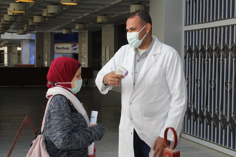 Strict precautionary measures before a building entry, temperature screening, face masks, hand gels royalty free stock photo