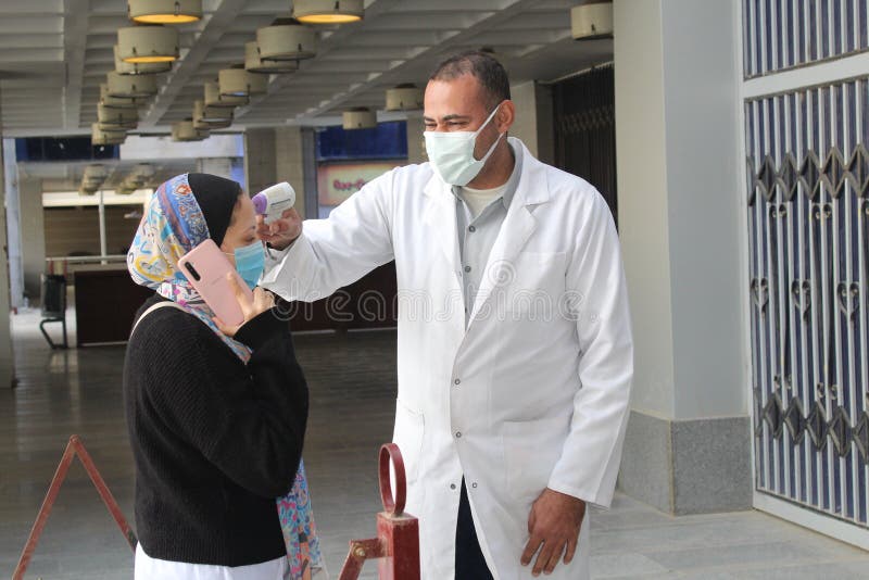 Strict precautionary measures before a building entry, temperature screening, face masks, hand gels stock images