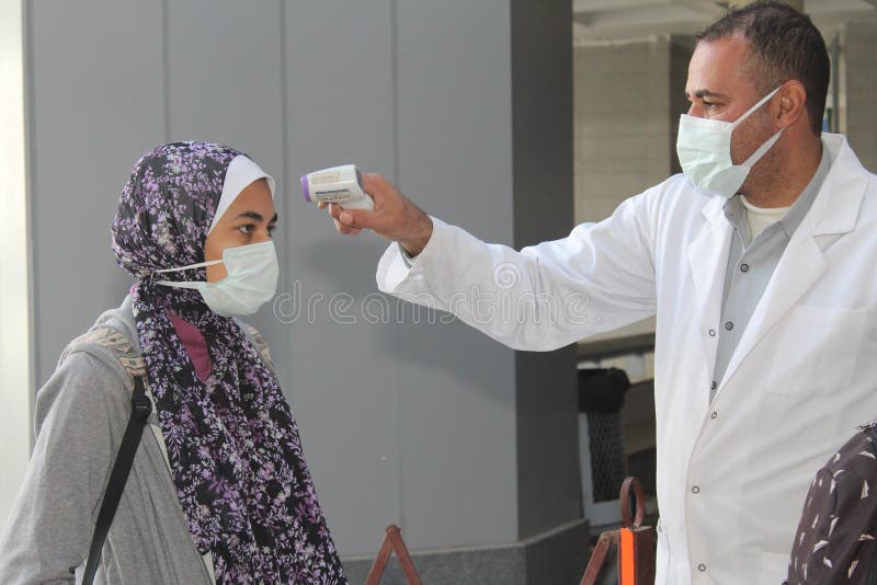 Strict precautionary measures before a building entry, temperature screening, face masks, hand gels royalty free stock images