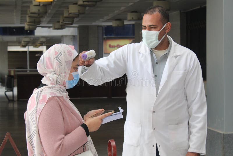 Strict precautionary measures before a building entry, temperature screening, face masks, hand gels royalty free stock photos