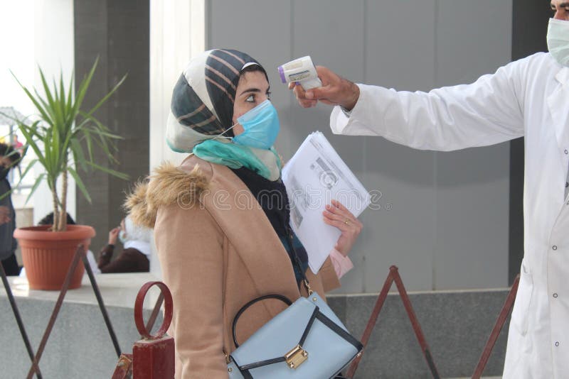 Strict precautionary measures before a building entry, temperature screening, face masks, hand gels stock image