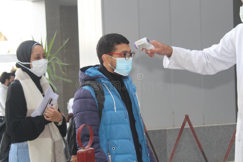 Strict precautionary measures before a building entry, temperature screening, face masks, hand gels stock photo