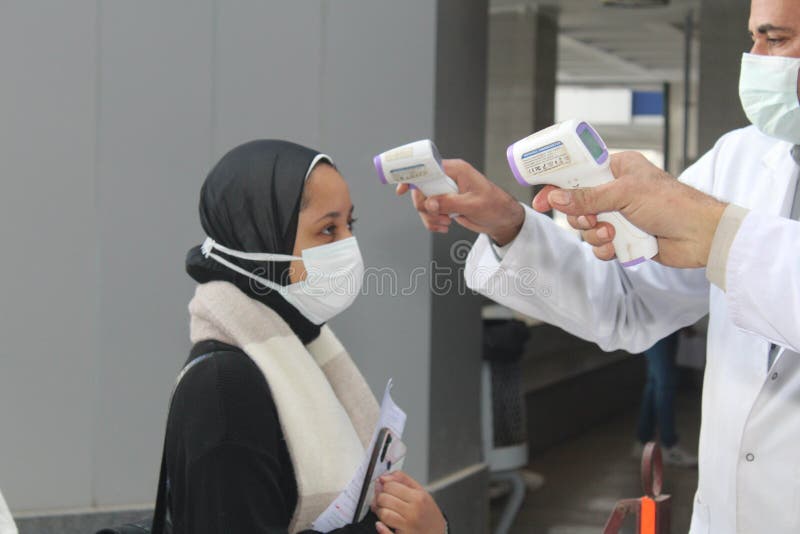 Strict precautionary measures before a building entry, temperature screening, face masks, hand gels stock images