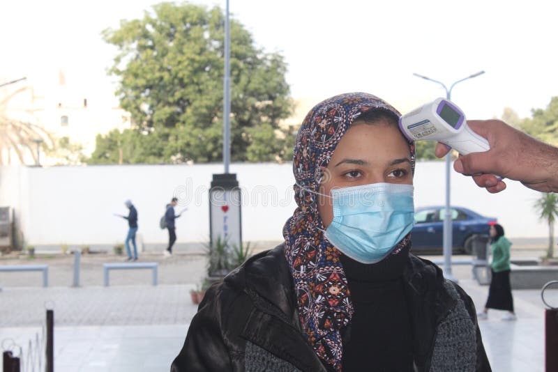 Strict precautionary measures before a building entry, temperature screening, face masks, hand gels stock photo