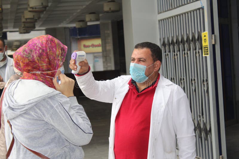 Strict precautionary measures before a building entry, temperature screening, face masks, hand gels stock images