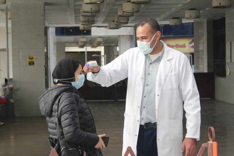 Strict precautionary measures before a building entry, temperature screening, face masks, hand gels stock photos