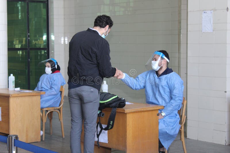 Strict precautionary measures before a building entry, temperature screening, face masks, hand gels stock photo