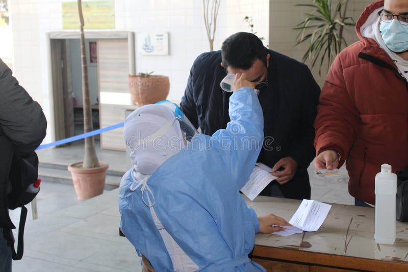 Strict precautionary measures before a building entry, temperature screening, face masks, hand gels stock photography