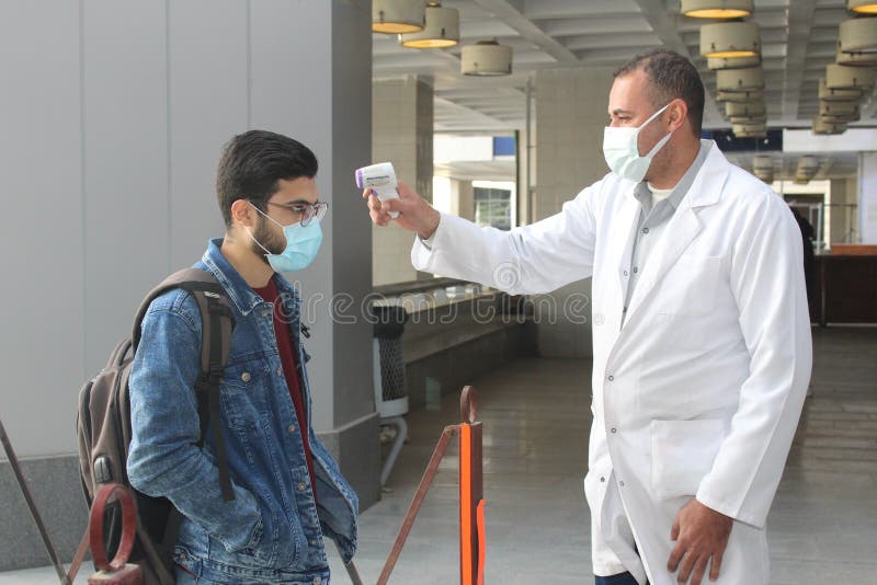Strict precautionary measures before a building entry, temperature screening, face masks, hand gels royalty free stock photography
