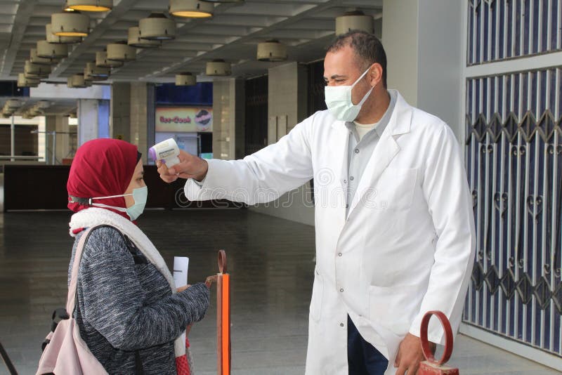 Strict precautionary measures before a building entry, temperature screening, face masks, hand gels stock photography