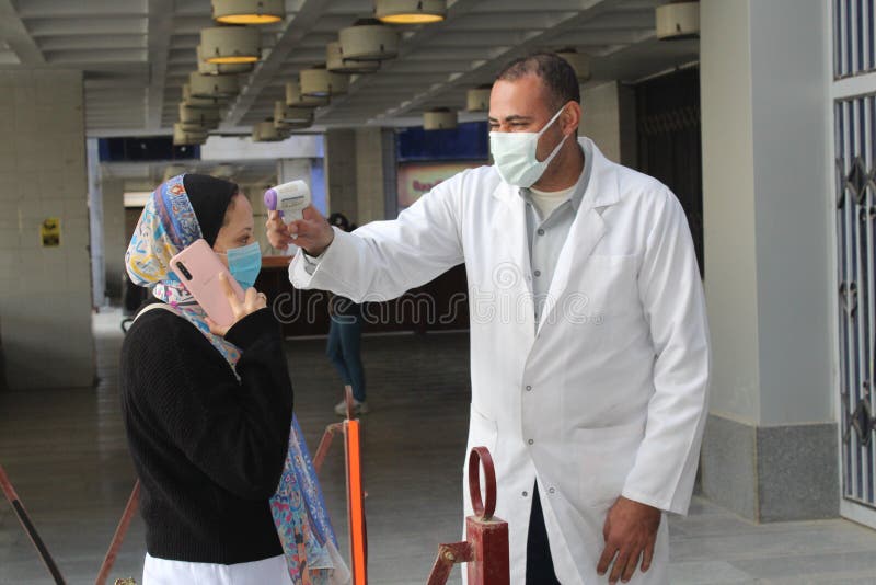Strict precautionary measures before a building entry, temperature screening, face masks, hand gels royalty free stock images