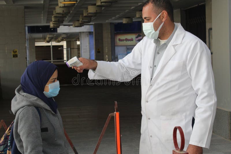 Strict precautionary measures before a building entry, temperature screening, face masks, hand gels royalty free stock photos