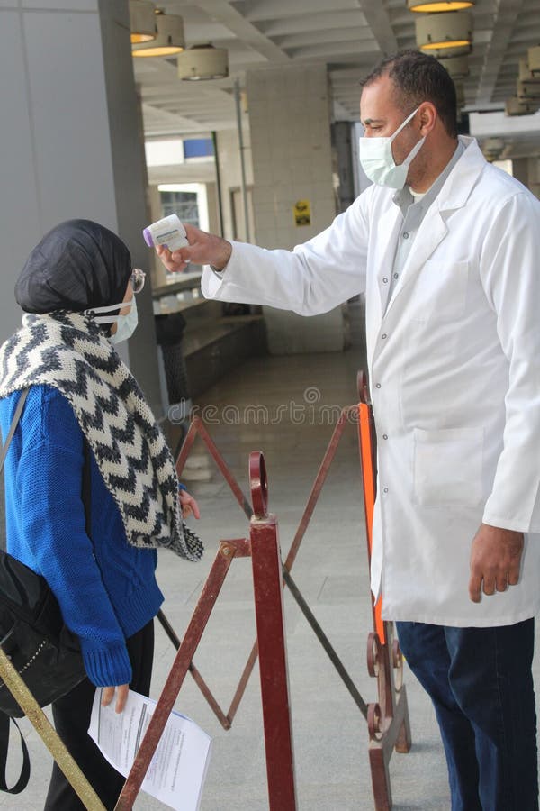 Strict precautionary measures before a building entry, temperature screening, face masks, hand gels royalty free stock photos