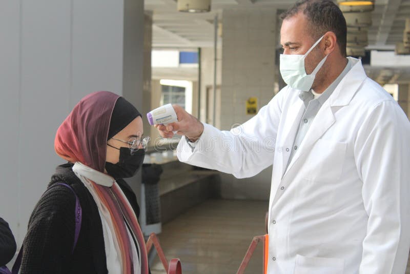 Strict precautionary measures before a building entry, temperature screening, face masks, hand gels royalty free stock images