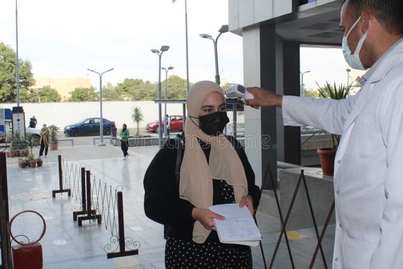 Strict precautionary measures before a building entry, temperature screening, face masks, hand gels royalty free stock photo