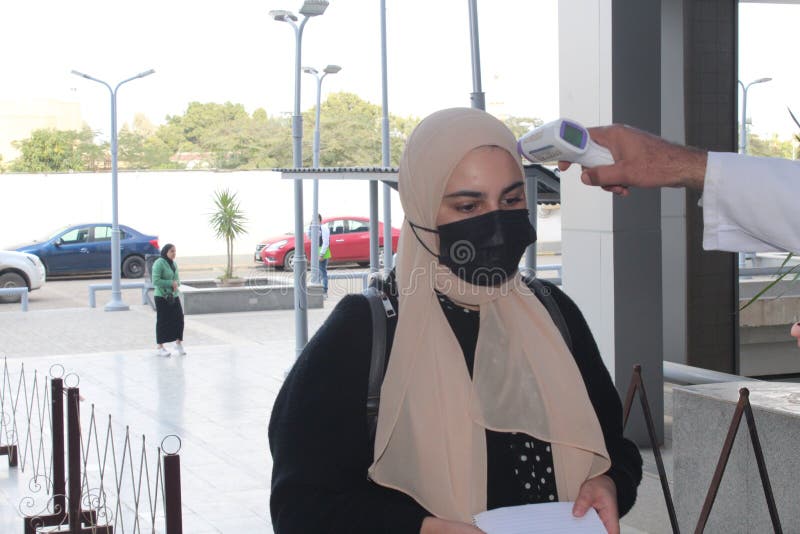 Strict precautionary measures before a building entry, temperature screening, face masks, hand gels stock photos