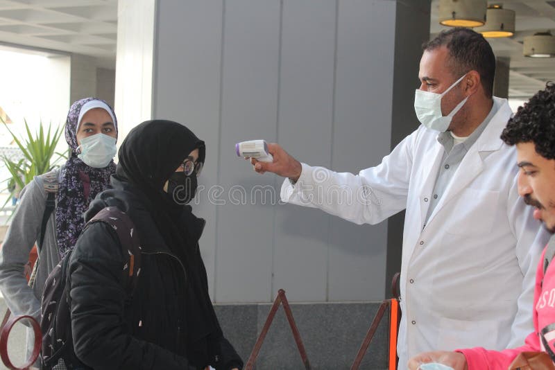Strict precautionary measures before a building entry, temperature screening, face masks, hand gels royalty free stock photography