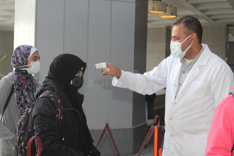 Strict precautionary measures before a building entry, temperature screening, face masks, hand gels stock image