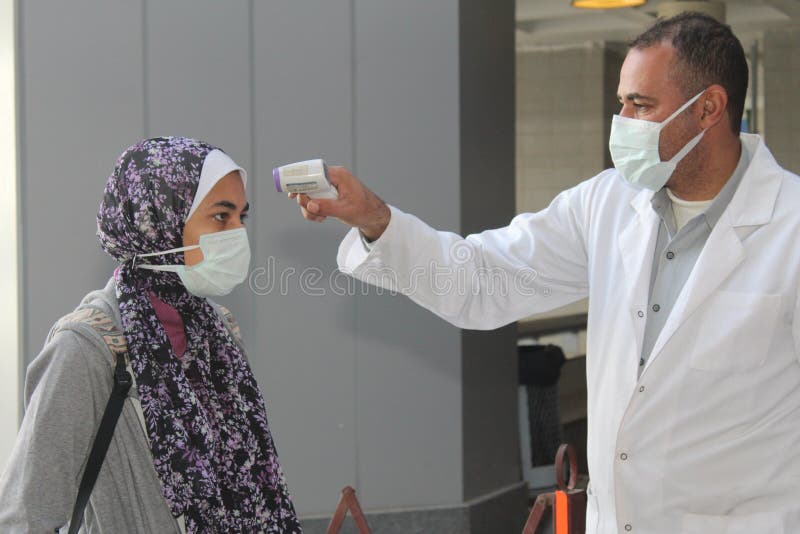 Strict precautionary measures before a building entry, temperature screening, face masks, hand gels royalty free stock image