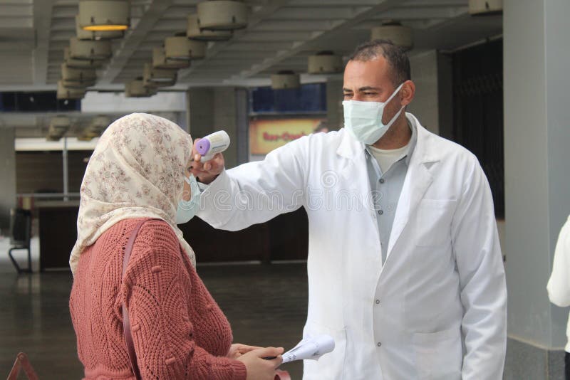 Strict precautionary measures before a building entry, temperature screening, face masks, hand gels royalty free stock images