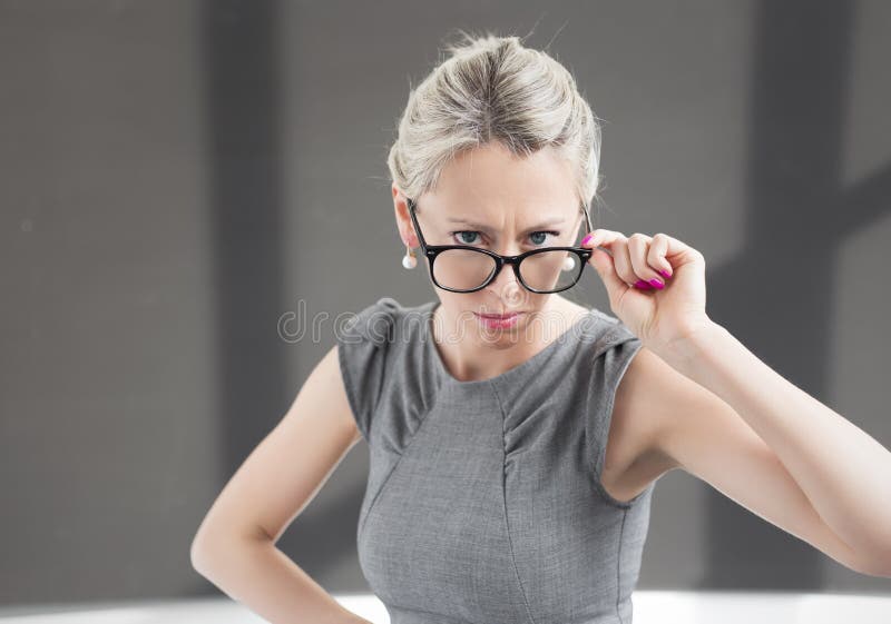 Strict teacher looking through glasses with serious expression royalty free stock photo Strict teacher looking through glasses with serious expression royalty free stock photo