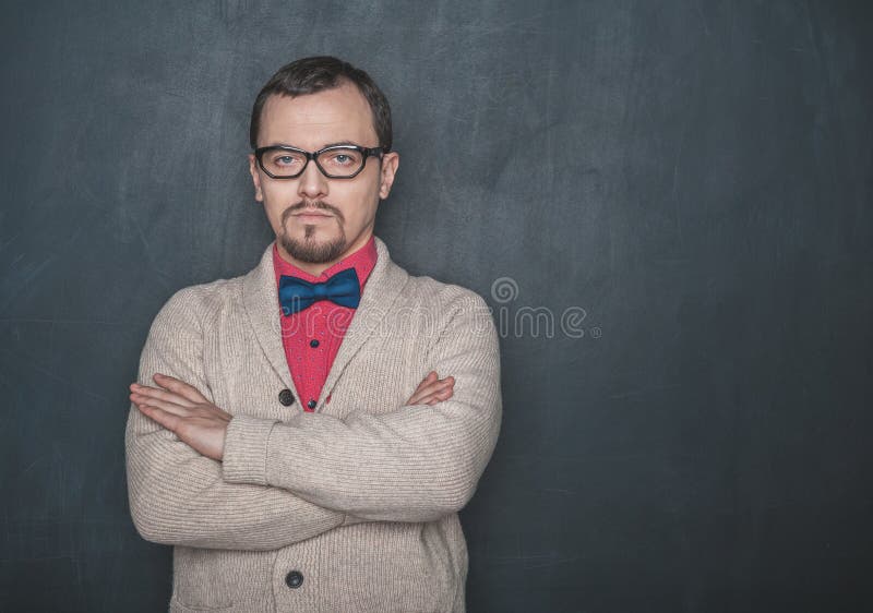 Strict teacher vintage style in eyeglasses looking at you on blackboard royalty free stock photos Strict teacher vintage style in eyeglasses looking at you on blackboard royalty free stock photos