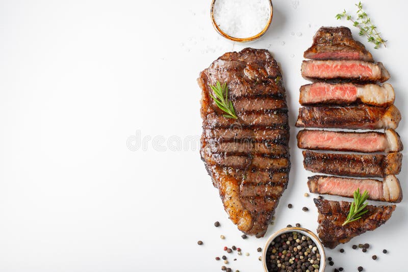 Striploin marbré grillé de deux biftecks de boeuf avec des épices d'isolement sur le fond blanc, vue supérieure avec l'espace de photos libres de droits Striploin marbré grillé de deux biftecks de boeuf avec des épices d'isolement sur le fond blanc, vue supérieure avec l'espace de photos libres de droits