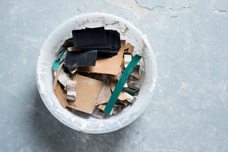 Strips of Used and Unused Sandpaper in a Plastic Bowl Stock Photo