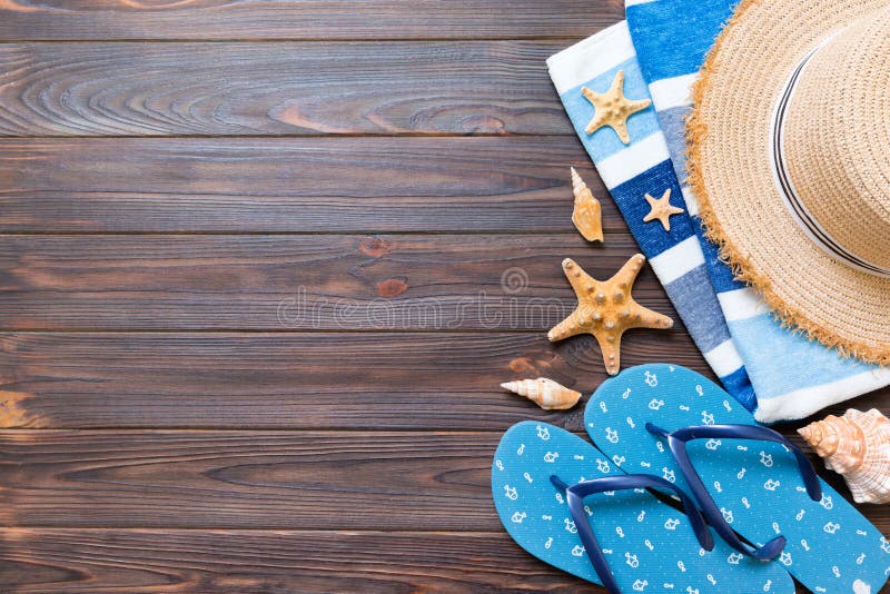 Strohhut, blaue Flipflops, Tuch und Starfish auf einem dunklen hölzernen Hintergrund DraufsichtSommerferienkonzept mit Kopienraum lizenzfreie stockfotografie Strohhut, blaue Flipflops, Tuch und Starfish auf einem dunklen hölzernen Hintergrund DraufsichtSommerferienkonzept mit Kopienraum lizenzfreie stockfotografie