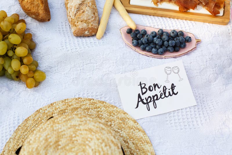 Strohhut legen auf eine weiße Picknickdecke nahe bei Nummernschild Bon apetit hellem Sommertageshintergrund Sommerwochenendenfrei stockbild Strohhut legen auf eine weiße Picknickdecke nahe bei Nummernschild Bon apetit hellem Sommertageshintergrund Sommerwochenendenfrei stockbild
