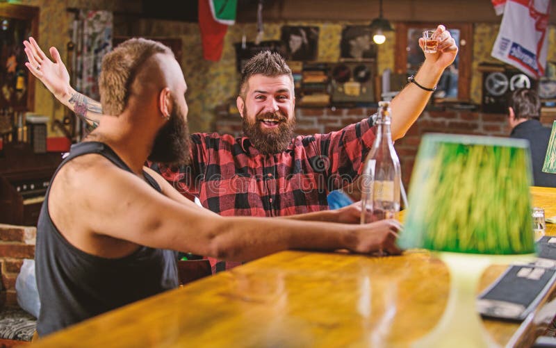 Strong alcohol drinks. Alcohol addiction. Friends relaxing in pub. Men drunk relaxing at pub having fun. Hipster brutal stock image Strong alcohol drinks. Alcohol addiction. Friends relaxing in pub. Men drunk relaxing at pub having fun. Hipster brutal stock image