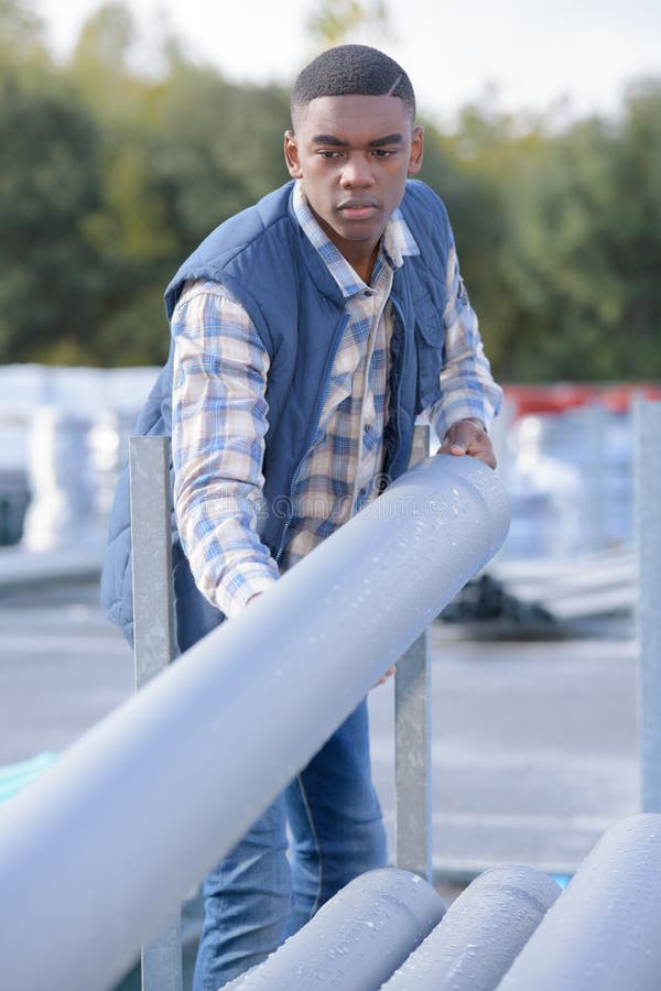 Strong construction worker rolling concrete pipe stock photos Strong construction worker rolling concrete pipe stock photos
