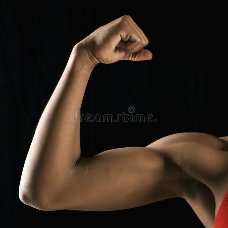 Arm of African American woman flexing muscular bicep. Arm of African American woman flexing muscular bicep.