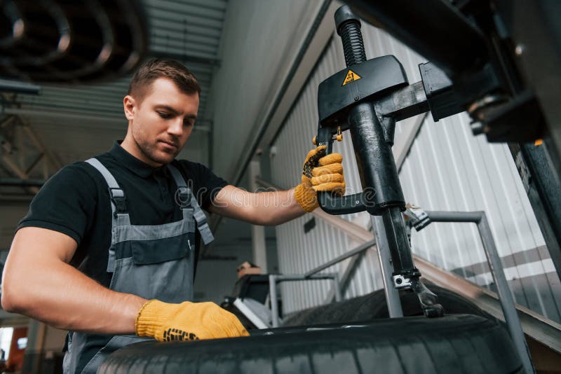 Strong Hands. Man in Uniform is Working in the Auto Service Stock Photo
