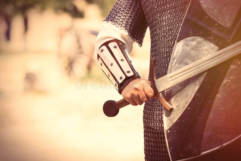 Strong knight hand with beautiful sword and shield on the middle
