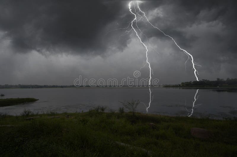 Strong lightning on the shore of the lake royalty free stock photo