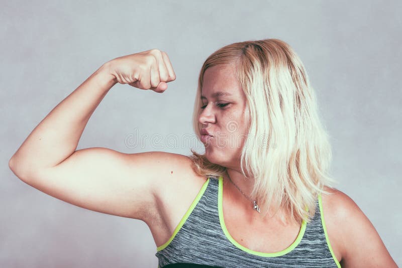 Strong muscular sporty woman flexing biceps