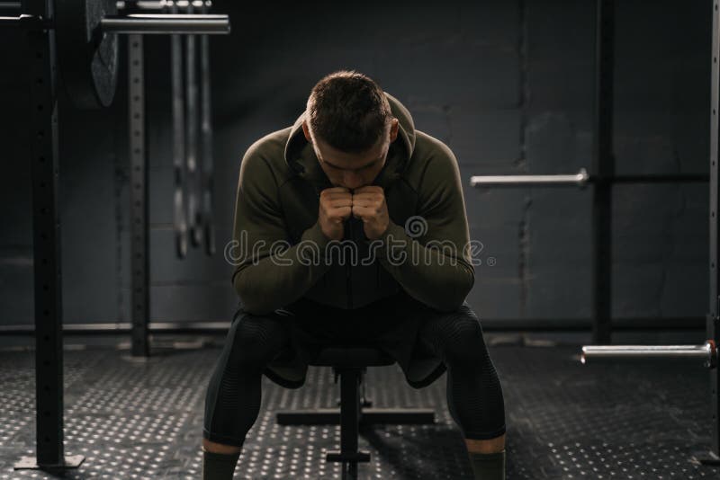 Strong sporty man sitting on gym bench suffering breakdown to overcome stock image Strong sporty man sitting on gym bench suffering breakdown to overcome stock image