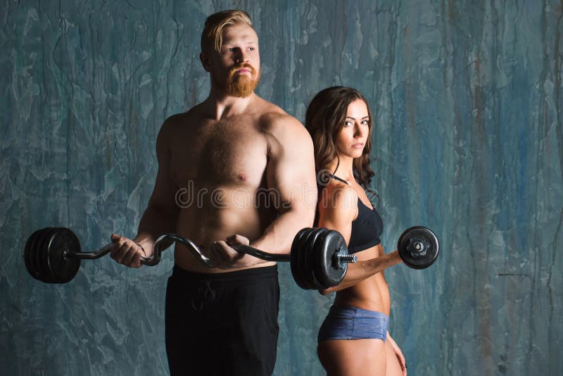 Strong young couple working out with dumbbells. stock photos Strong young couple working out with dumbbells. stock photos