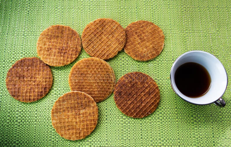 Stroopwafels met koffie op een lijst met groen tafelkleed stock foto Stroopwafels met koffie op een lijst met groen tafelkleed stock foto