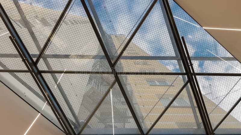 Structural glazing of the facade. Abstract background with glass ceiling elements in a modern building. view of the blue sky