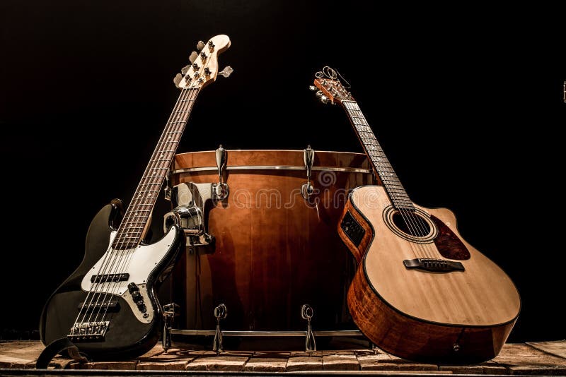 strumenti musicali, chitarra acustica del barilotto della grancassa e basso elettrico su un fondo nero immagini stock strumenti musicali, chitarra acustica del barilotto della grancassa e basso elettrico su un fondo nero immagini stock