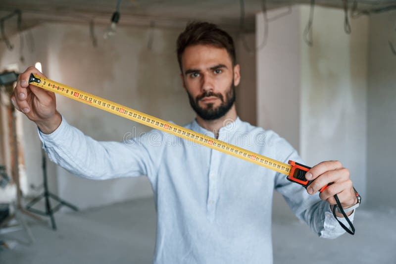 Strumento di misura del righello. l'uomo sta riparando nell'appartamento fotografia stock libera da diritti