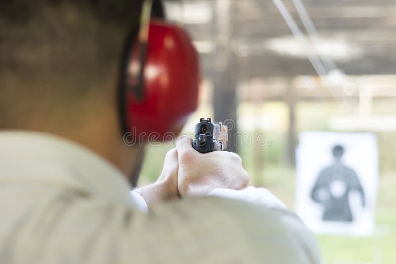 Strzelać z pistoletem przy celem w Mknącym pasmie Mężczyzna Ćwiczy ogienia krócicy strzelanina