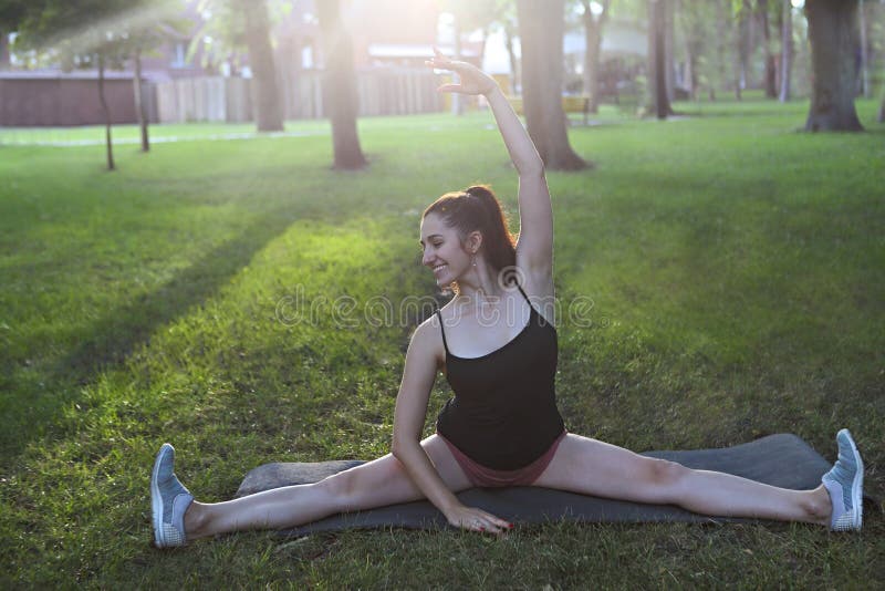 Sträckning av kvinnan i utomhus- övning som ler lycklig görande elasticitet