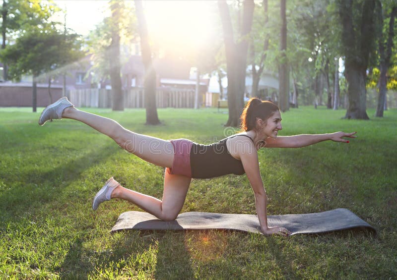 Sträckning av kvinnan i utomhus- övning som ler lycklig görande elasticitet