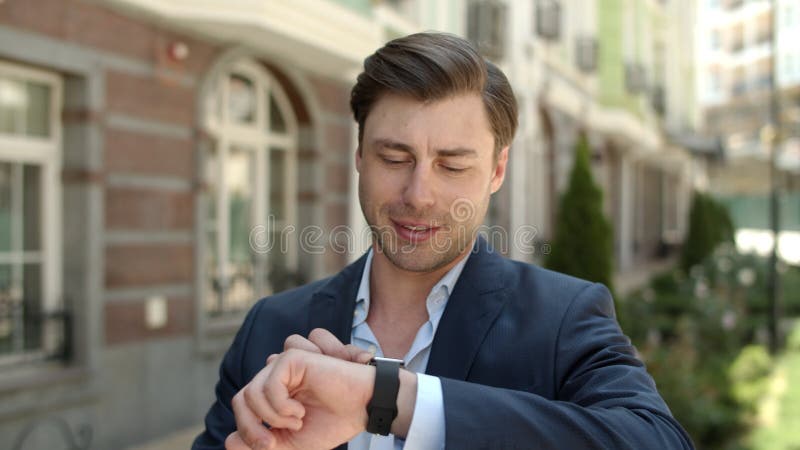 Strålmannen använder smart klocka utomhus Man tittar på smart watch på gatan arkivfilmer