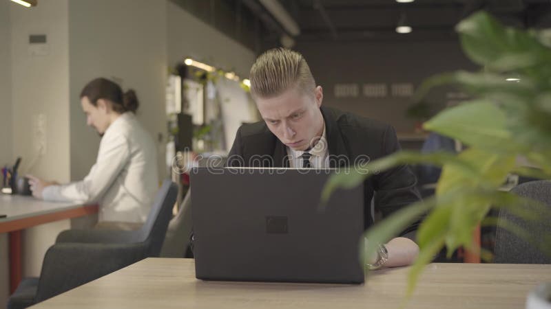 Strålningskänslig bild av rödspetskaukasisk man som tittar på skärmen på den bärbara datorn och skriver på tangentbordet Framgång