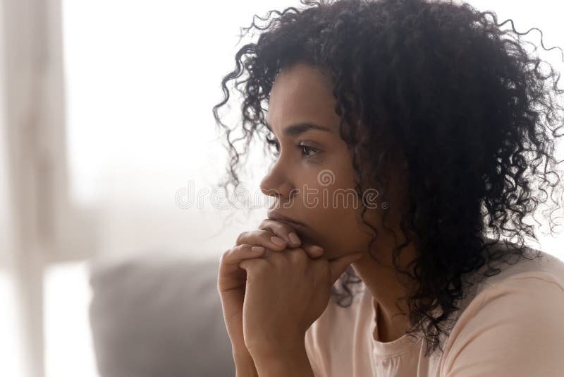 Close up side profile view of pensive young african American woman thinking of relationships problems, thoughtful black biracial female feel despair lost in thoughts consider life trouble or drama. Close up side profile view of pensive young african American woman thinking of relationships problems, thoughtful black biracial female feel despair lost in thoughts consider life trouble or drama