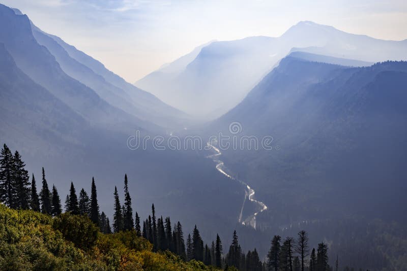 Ström till och med en dal för dimmigt berg i Montana